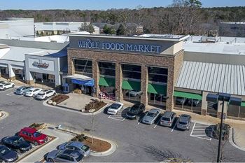 A Whole Foods Market is shown in an aerial view with cars parked in the lot.